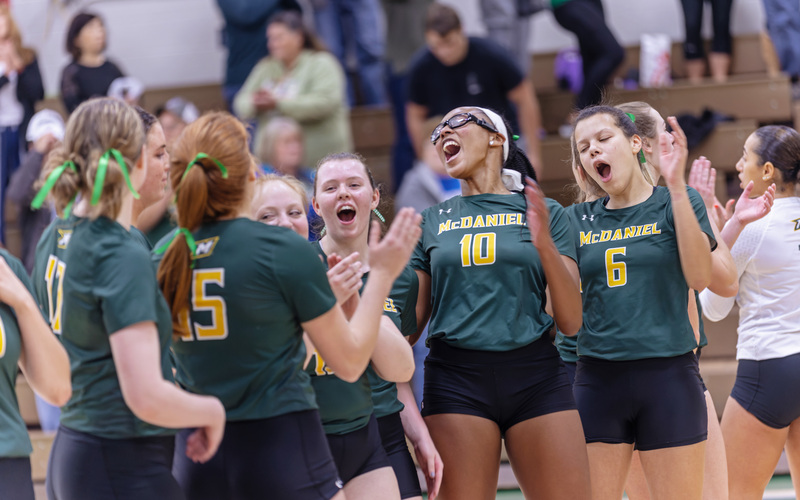 Volleyball players celebrate on the court